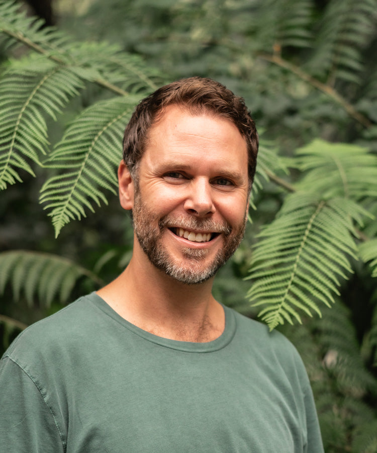David Lloyd smiling, wearing a green t-shirt, portrait shot | About Page Profile