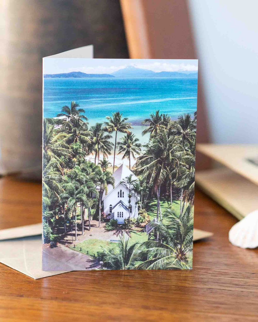 A Slice of Paradise Greeting Card with a white church, palm trees, and turquoise ocean scenery.