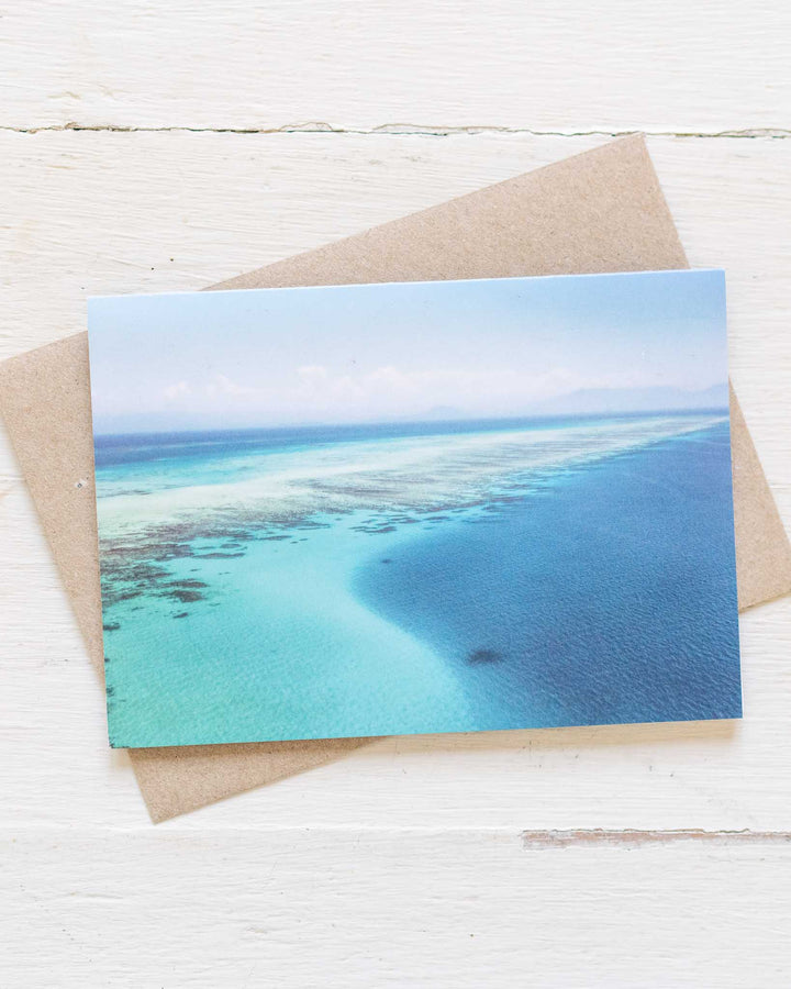 As Far As The Eye Can See“ greeting card with a turquoise ocean against a white background.