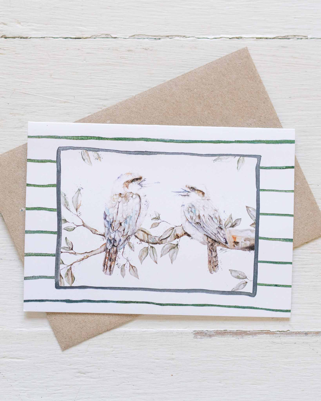 Branching Out Together greeting card with two kookaburras on striped background, paired with a brown envelope.