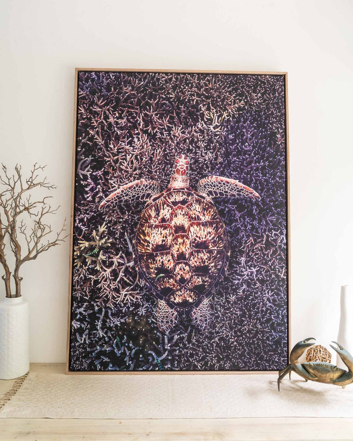 Coral Labyrinth framed print featuring a green sea turtle, shown with decor accents and a simple vase.