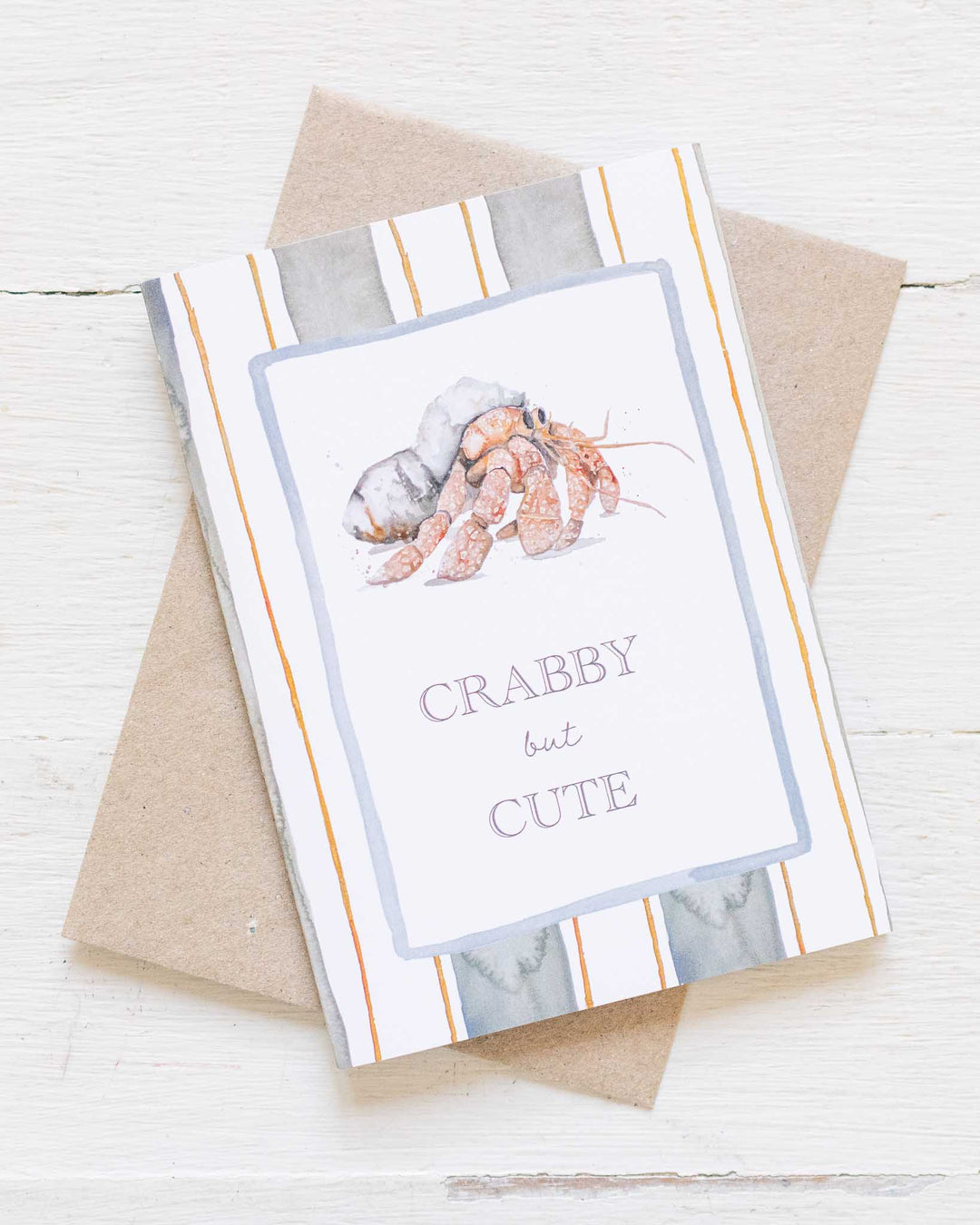 Crabby But Cute“ eco greeting card features a watercolor crab on a striped background, designed by Stephanie Elizabeth.