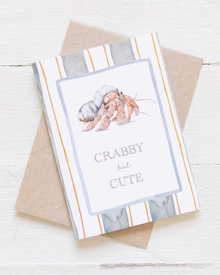 Crabby But Cute“ eco greeting card features a watercolor crab on a striped background, designed by Stephanie Elizabeth.