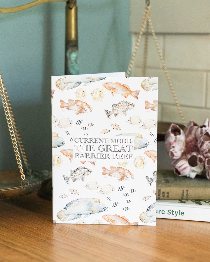 Current Mood: The Great Barrier Reef A5 lined notebook on a wooden table.