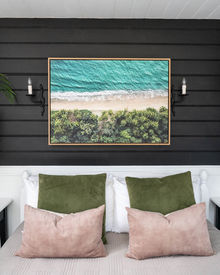 Emerald Tide aerial print of Four Mile Beach framed and displayed as wall art above a bed.