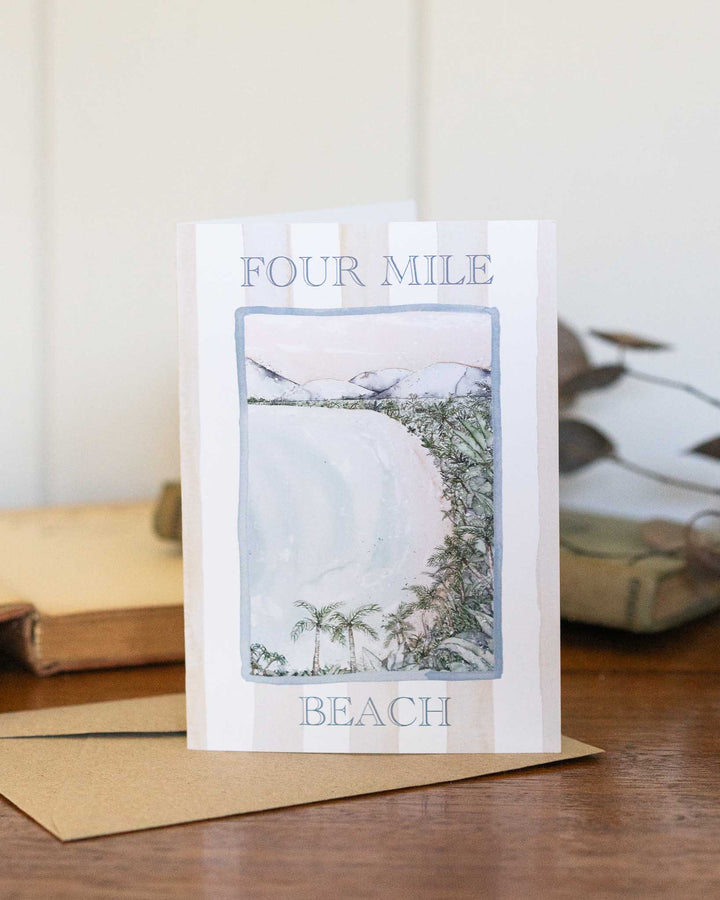 Four Mile Beach watercolor greeting card with envelopes displayed on a wooden table.