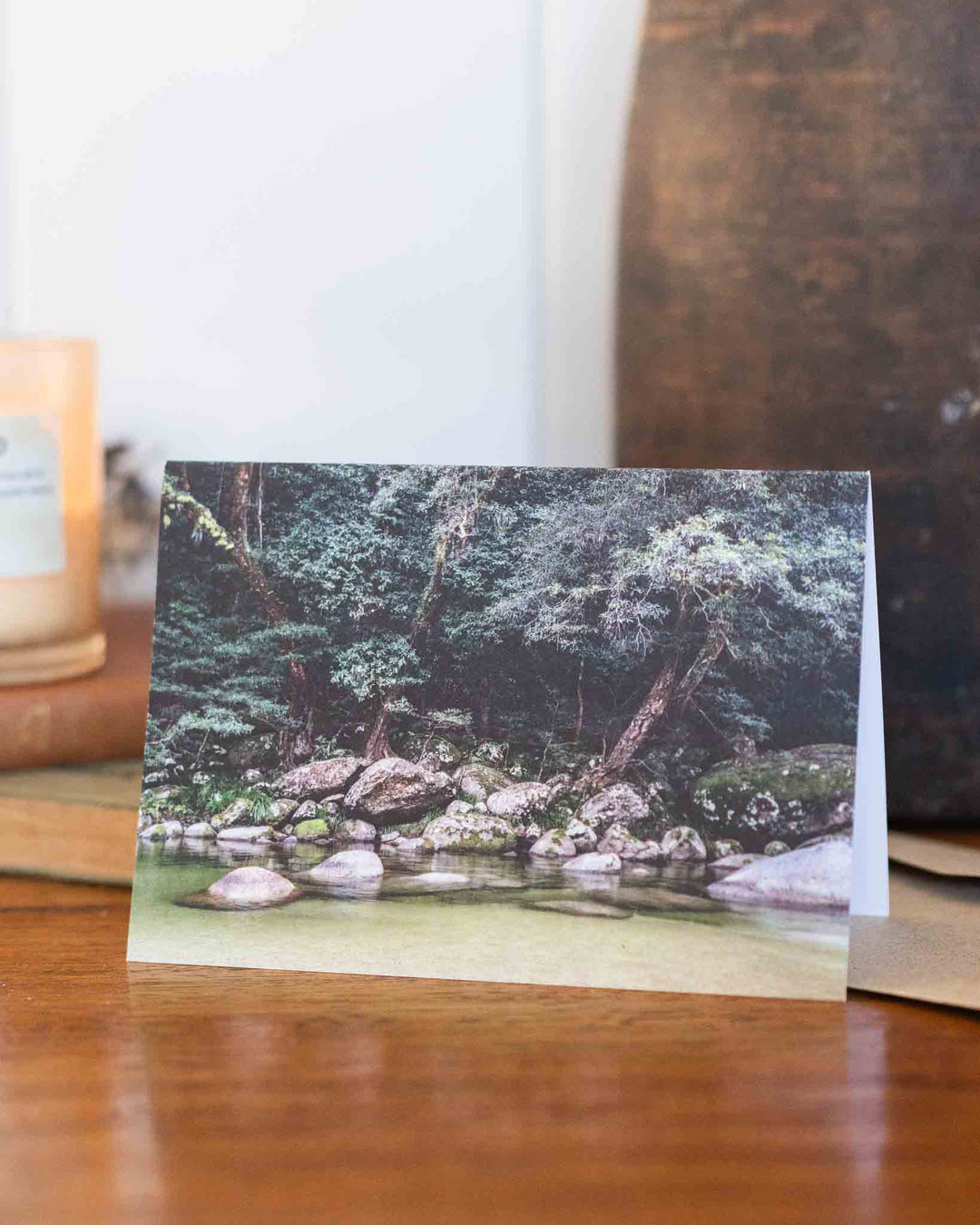 From the Gorge“ greeting card with a landscape of rocks, trees, and water displayed upright indoors.