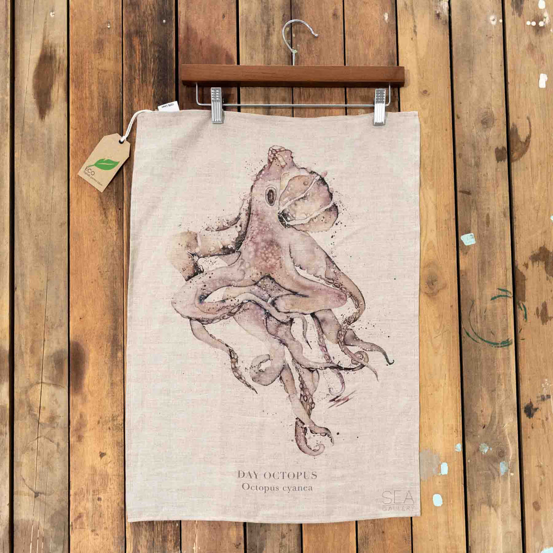 Octopus Linen Tea Towel featuring a detailed octopus illustration displayed against a wooden wall.