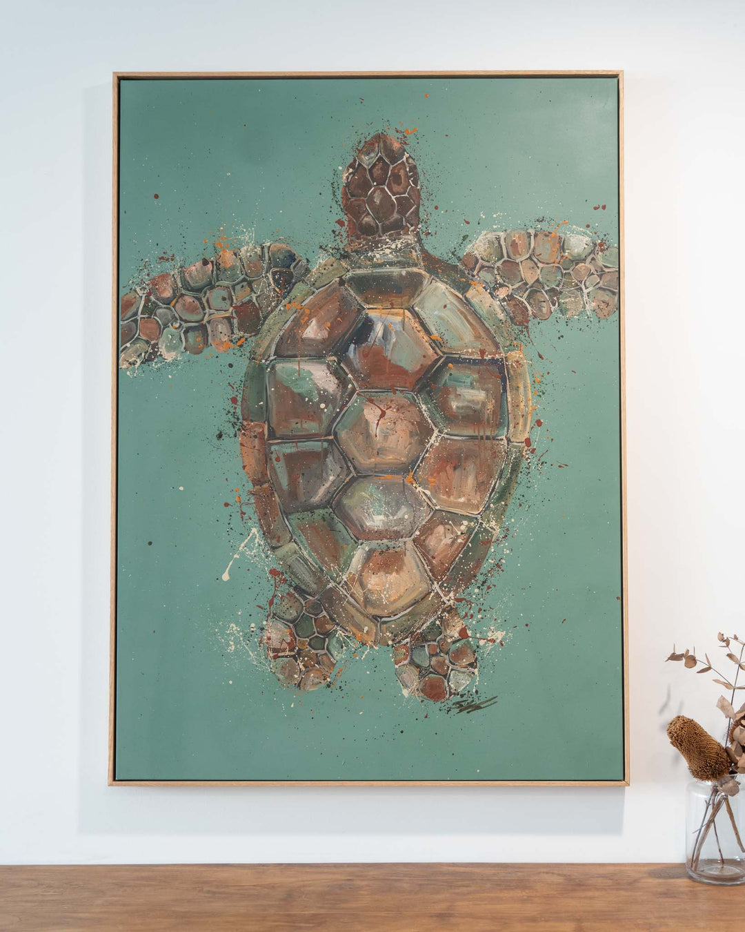 Running on Good Vibes“ artwork above a wooden surface, next to a vase holding dried flowers.