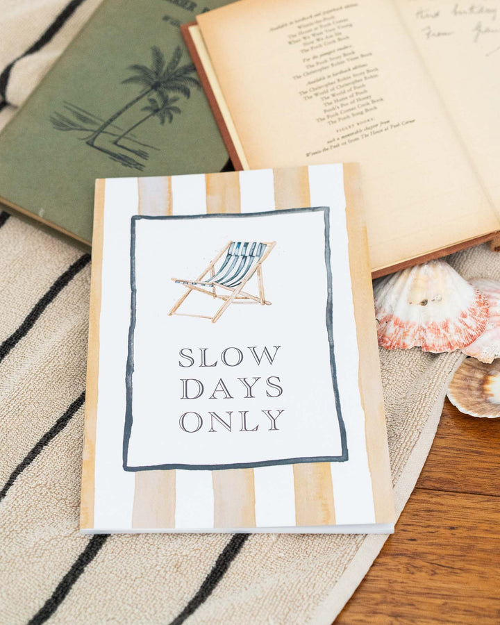 Slow Days Only A5 lined notebook with watercolor deck chair illustration and the words “SLOW DAYS ONLY” on the cover.