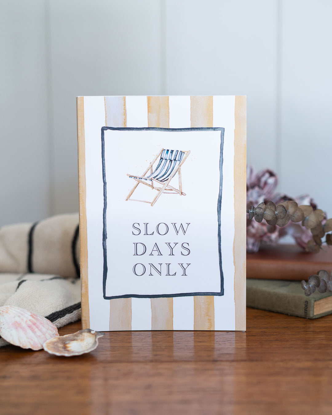 The Slow Days Only A5 notebook with a striped deck chair in soft watercolour illustration on the cover.
