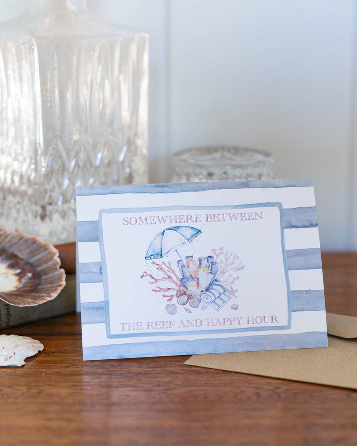 Greeting card titled “Somewhere Between the Reef and Happy Hour” with a watercolor beach scene.