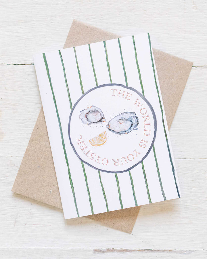 The World Is Your Oyster“ card with oysters, lemon slices, and green stripes. Eco-friendly design by Stephanie Elizabeth.