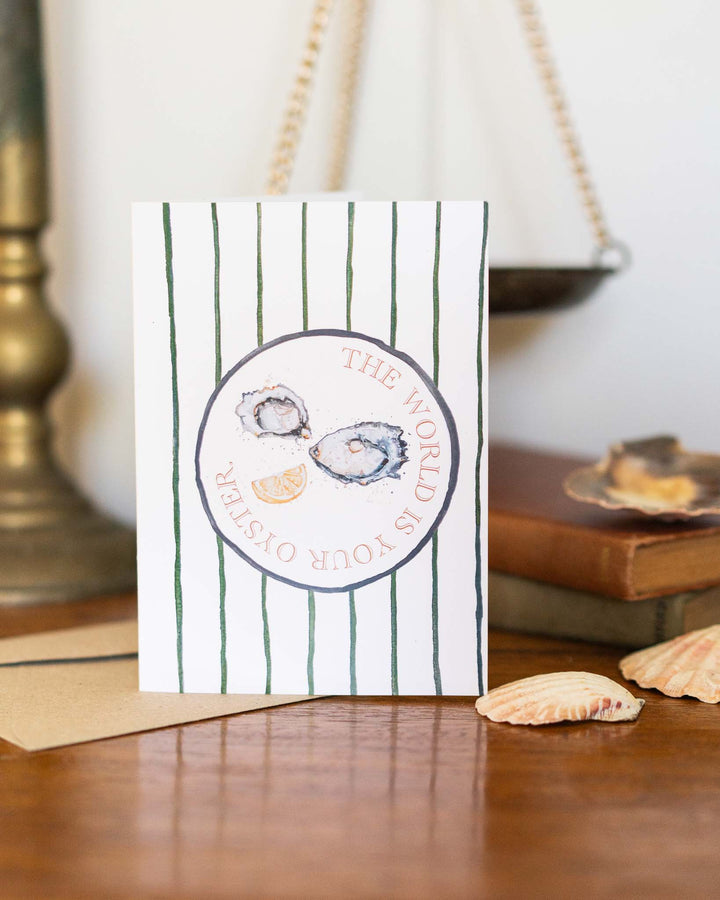 The World Is Your Oyster card with painted oysters, lemon slices, seashells, and books by Stephanie Elizabeth.