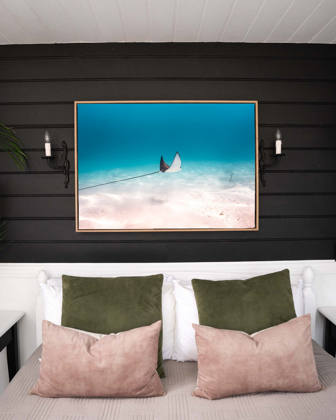 A Fleeting Moment – Eagle Ray, Underwater Photography by David Lloyd, framed canvas print in oak float frame, styled in a bedroom setting