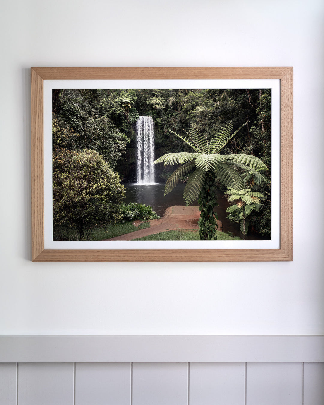Framed aerial photography print of a waterfall cascading into a rainforest pool, titled A Hop, Skip and Jump.