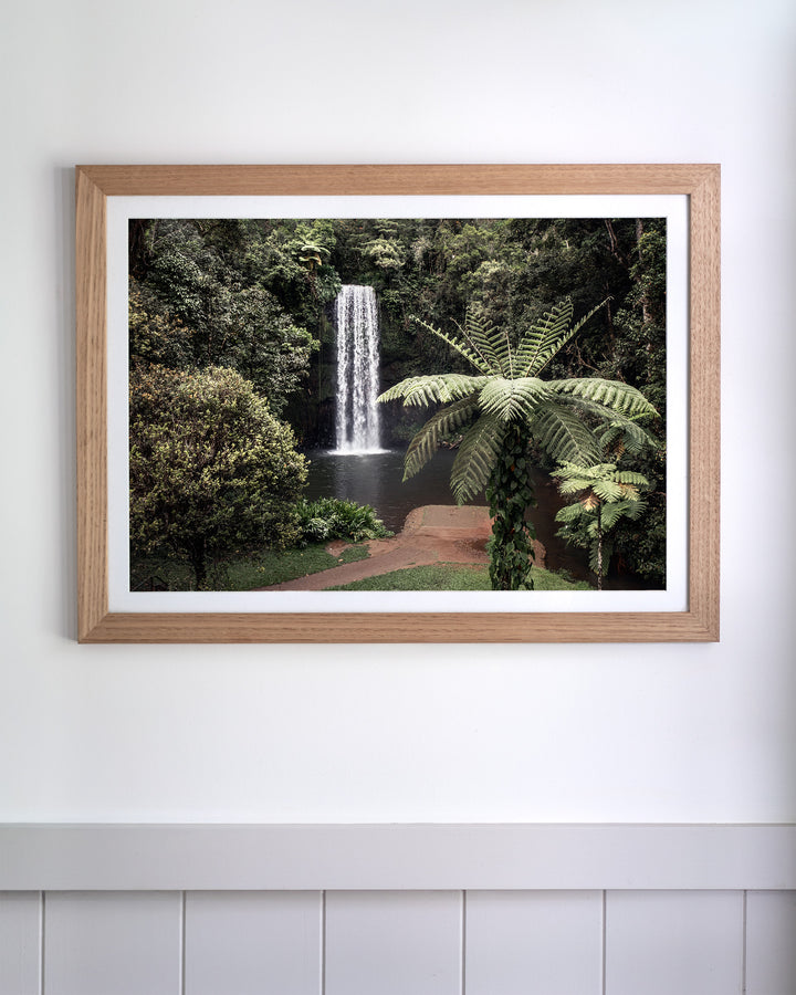 Framed aerial photography print of a waterfall cascading into a rainforest pool, titled A Hop, Skip and Jump.
