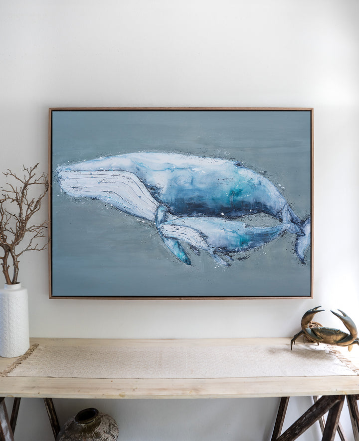 A Life Growing Together humpback whales fine art print by Stephanie Elizabeth, framed canvas in an oak frame above a side table