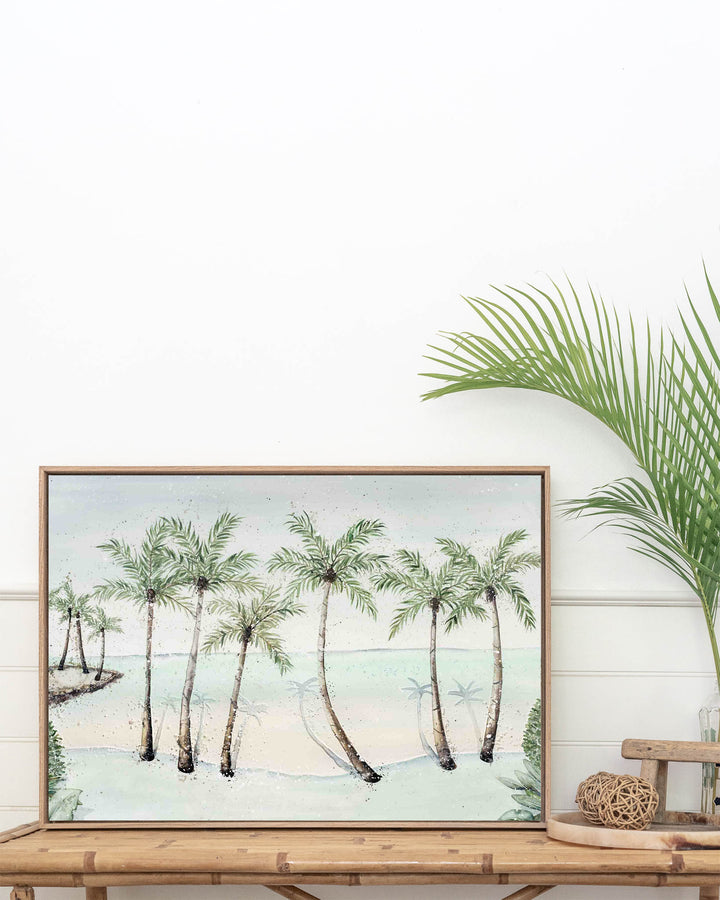 A Little Cove Love Story Port Douglas landscape fine art print by Stephanie Elizabeth, framed canvas in an oak frame above a console table