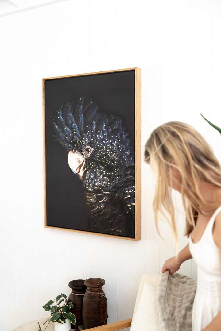 A woman adjusts a blanket beside “A Little Less Conversation” above two vases on a shelf.