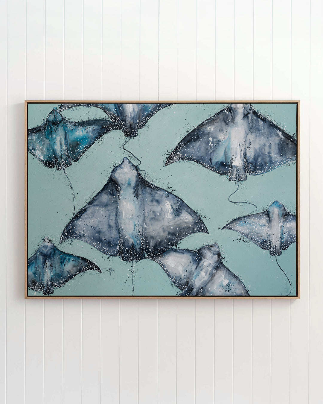 A Sea of Spots eagle rays fine art print by Stephanie Elizabeth, framed canvas in an oak frame