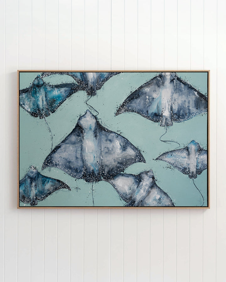 A Sea of Spots eagle rays fine art print by Stephanie Elizabeth, framed canvas in an oak frame