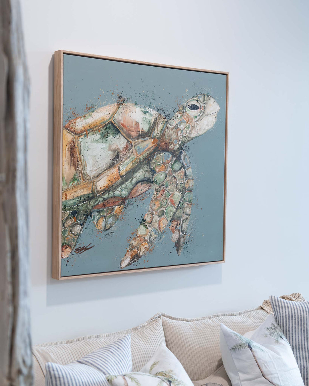 A Time to Rest artwork on a light blue wall above a beige couch for a modern, calming living room touch.