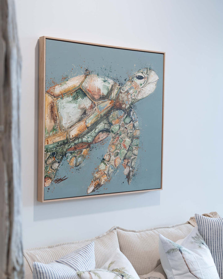 A Time to Rest artwork on a light blue wall above a beige couch for a modern, calming living room touch.