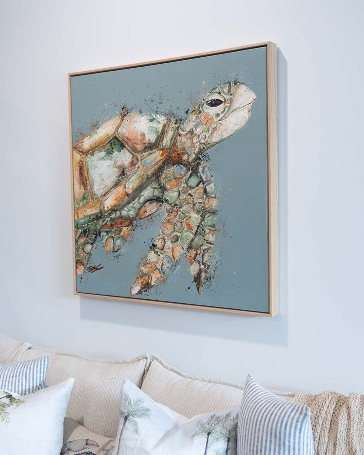 “A Time to Rest” artwork hangs above a sofa decorated with patterned pillows and a cozy knit throw.