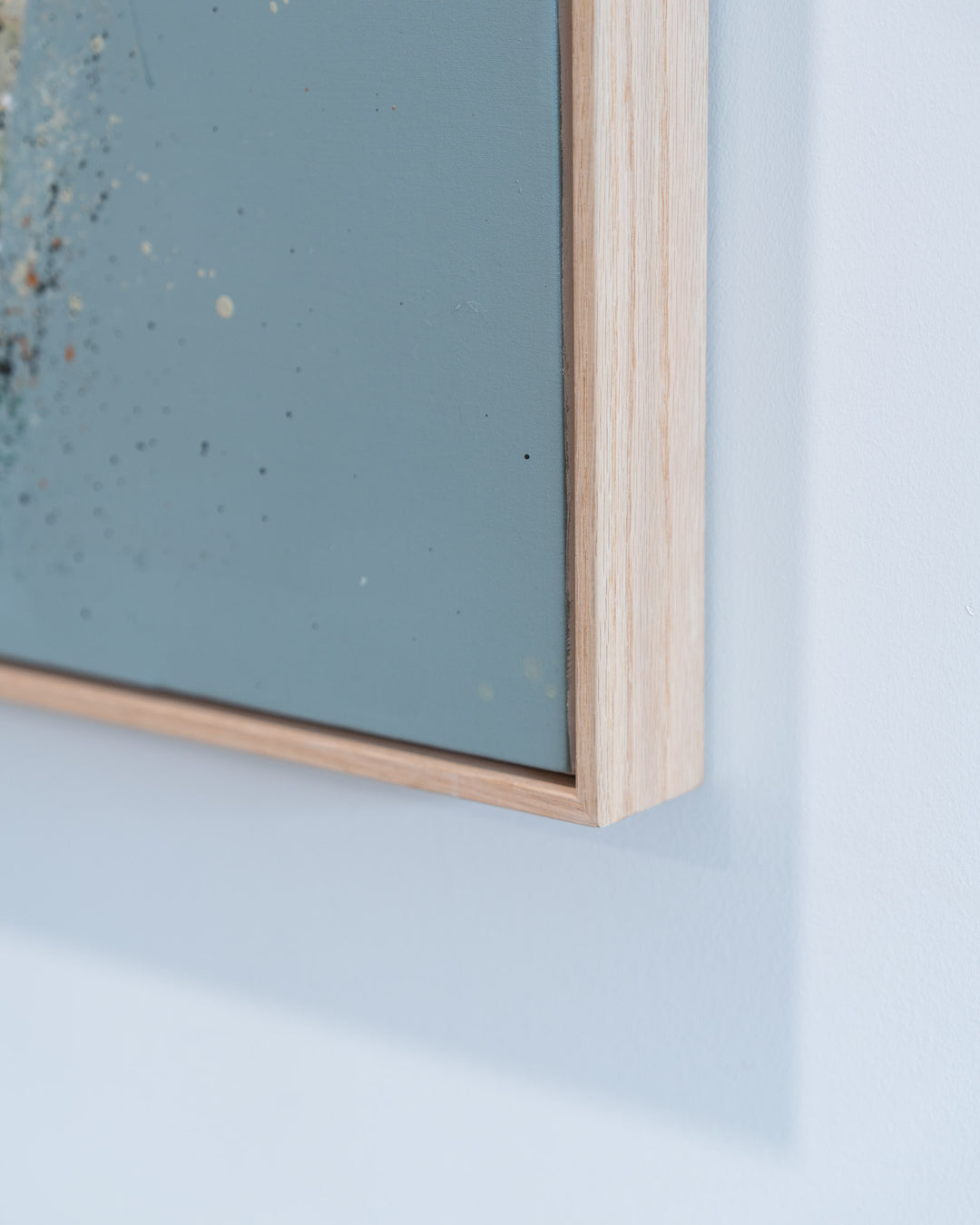 “A Time to Rest” in a light wood frame, blue and beige abstract design on a white wall.