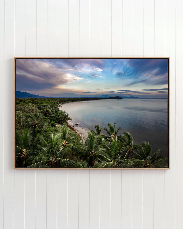 Framed print of After The Storm, an aerial view of the sunset at Four Mile Beach, Port Douglas, on a white paneled wall.