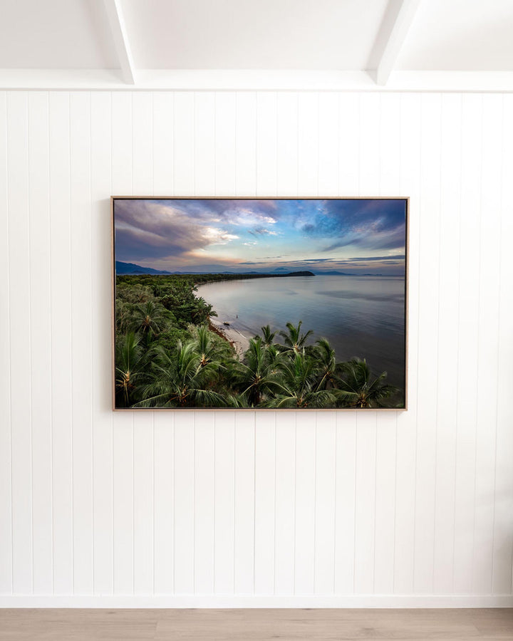 Framed aerial photograph, After The Storm | Four Mile Beach, Port Douglas, featuring a palm-fringed coastline at twilight.