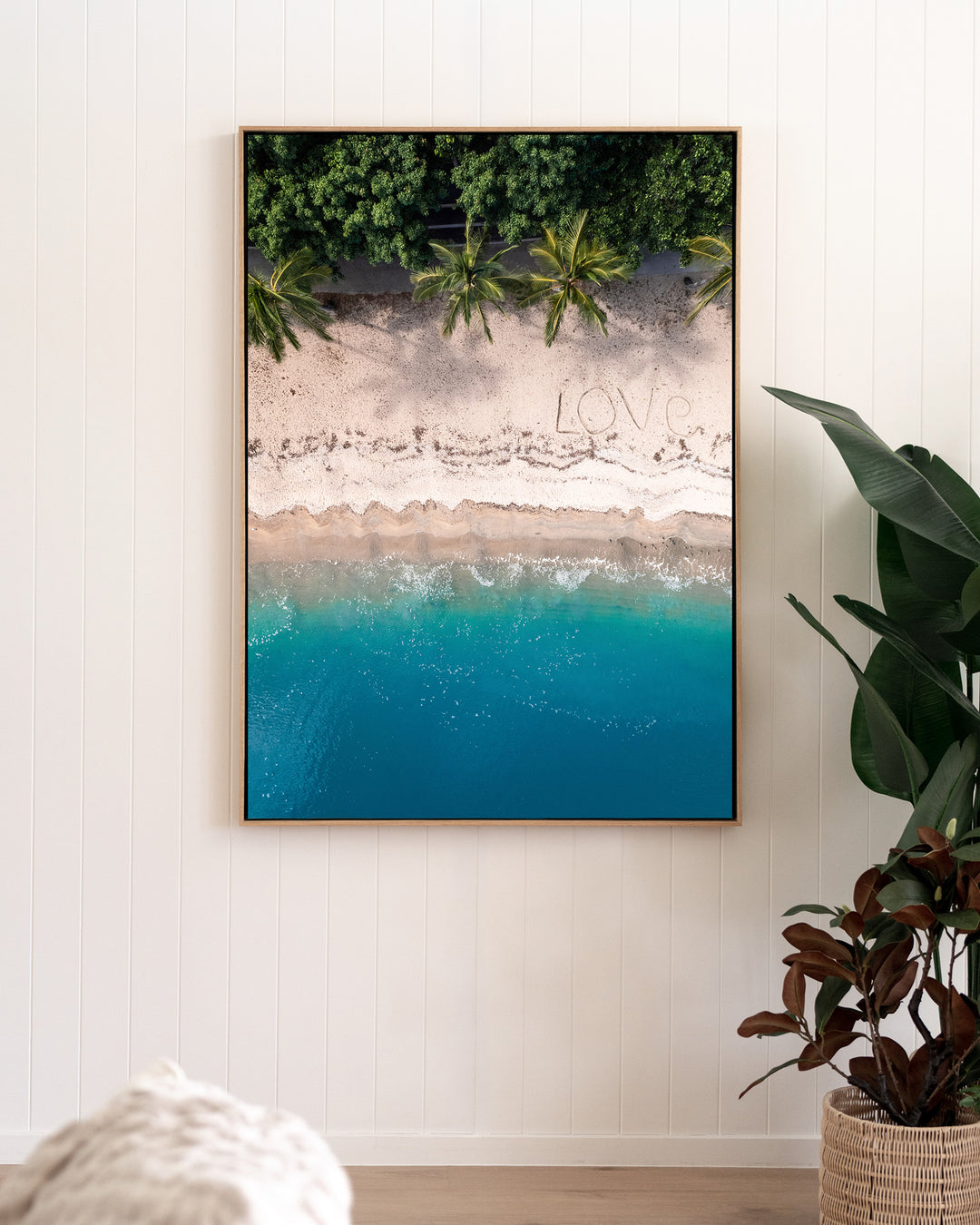 All You Need Is... – Whitsundays, Aerial Photography by David Lloyd, framed canvas print in oak float frame, styled in a living room setting