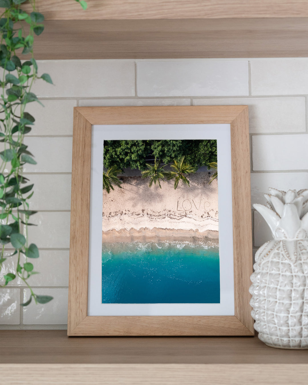 All You Need Is... – Whitsundays, Aerial Photography by David Lloyd, framed paper print in oak frame, styled in a kitchen shelf setting