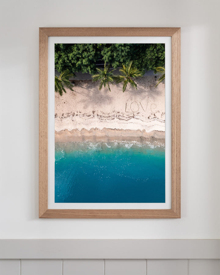Aerial beach wall art titled All You Need Is, featuring the word LOVE written in the sand at the Whitsundays.