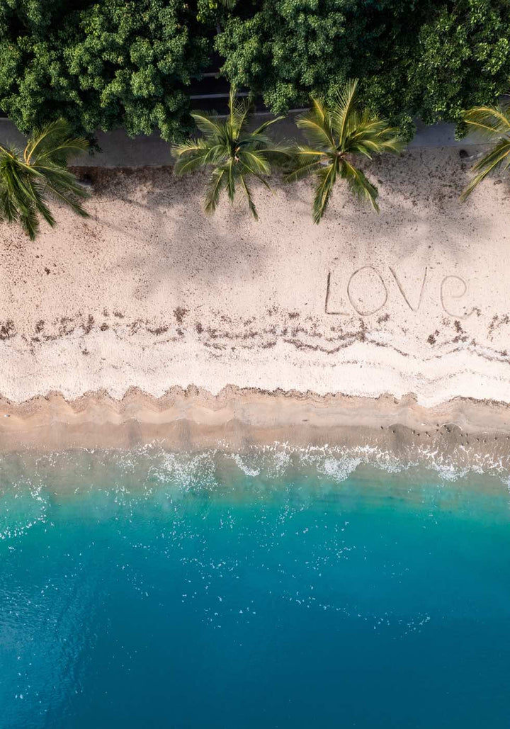 All You Need Is… – Aerial view of the Whitsundays with “Love” written on the beach, turquoise water and palm trees above and below | Unframed Rolled Print