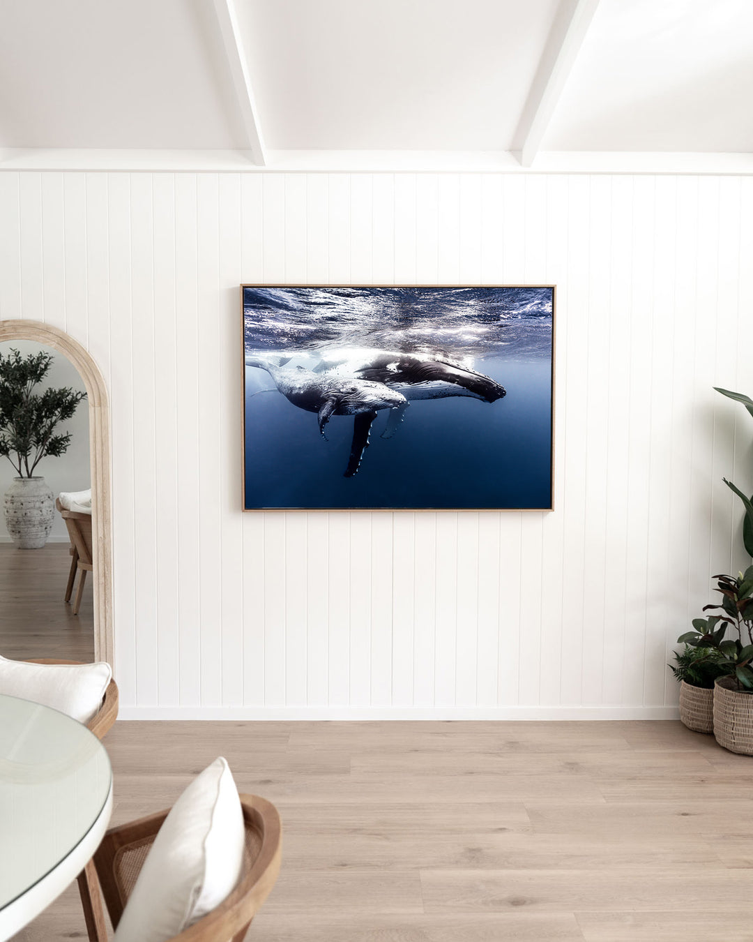 Along for the Ride – Humpback Whale Mum and Calf, Underwater Photography by David Lloyd, framed canvas print in oak float frame, styled in a dining room setting