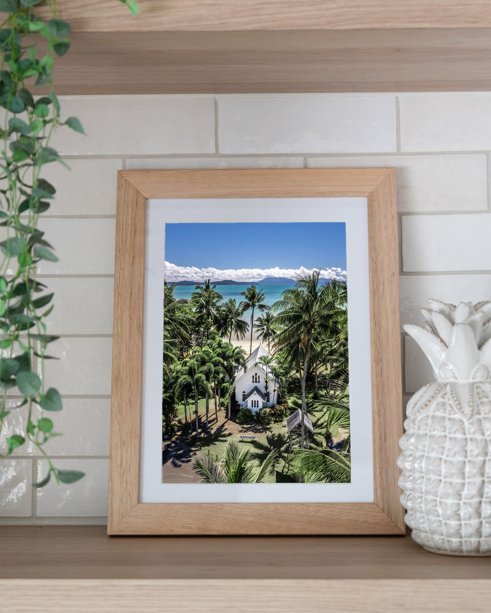 Always Forever – St Mary’s, Port Douglas, Aerial Photography by David Lloyd, framed paper print in oak frame, styled in a kitchen shelf setting