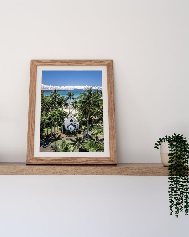 Always Forever – St Mary’s, Port Douglas, Aerial Photography by David Lloyd, framed paper print in oak frame, styled in a timber shelf setting