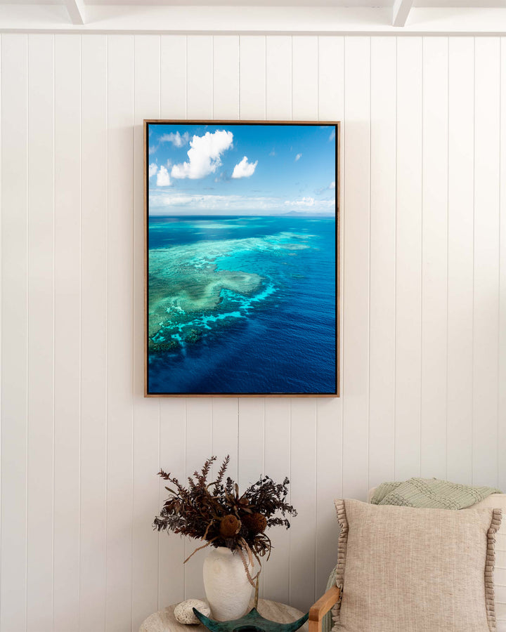 Always Take The Weather With You – Rudder Reef, Aerial Photography by David Lloyd, framed canvas print in oak float frame, styled in a bedroom setting