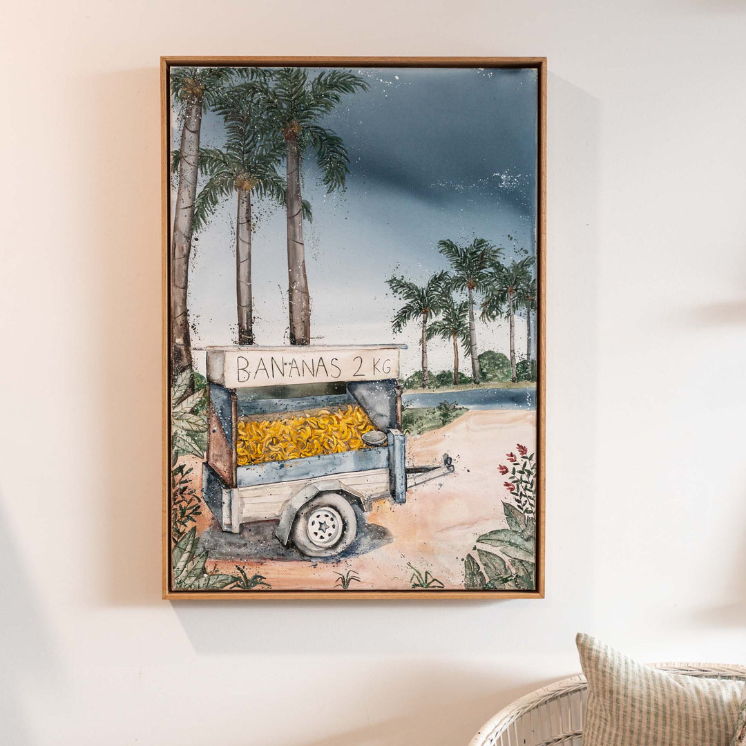 Banana Shack acrylic painting by Stephanie Elizabeth featuring a banana cart, displayed above a chair.
