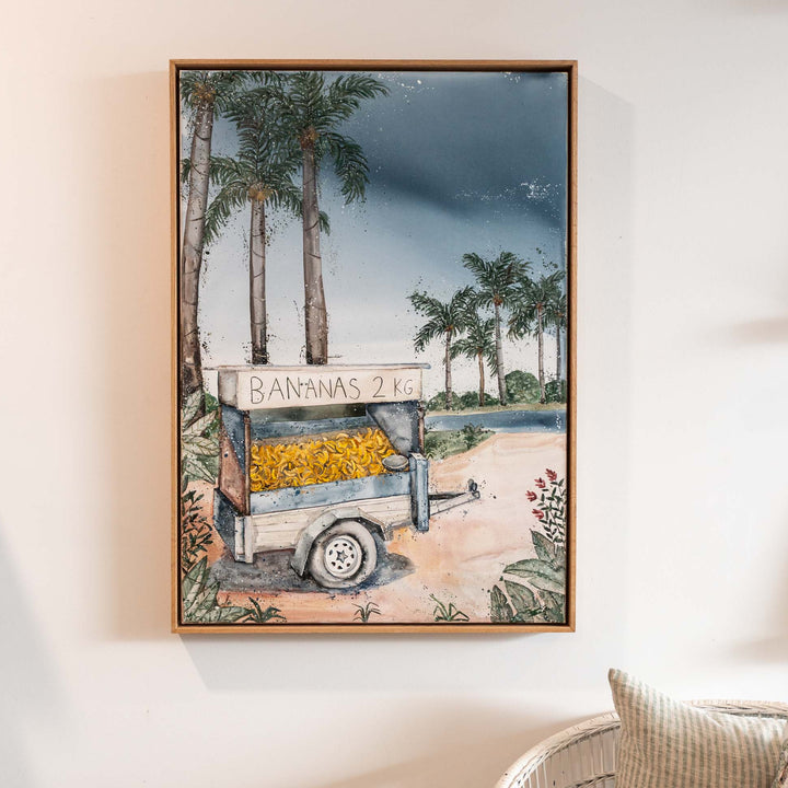 Banana Shack acrylic painting by Stephanie Elizabeth featuring a banana cart, displayed above a chair.