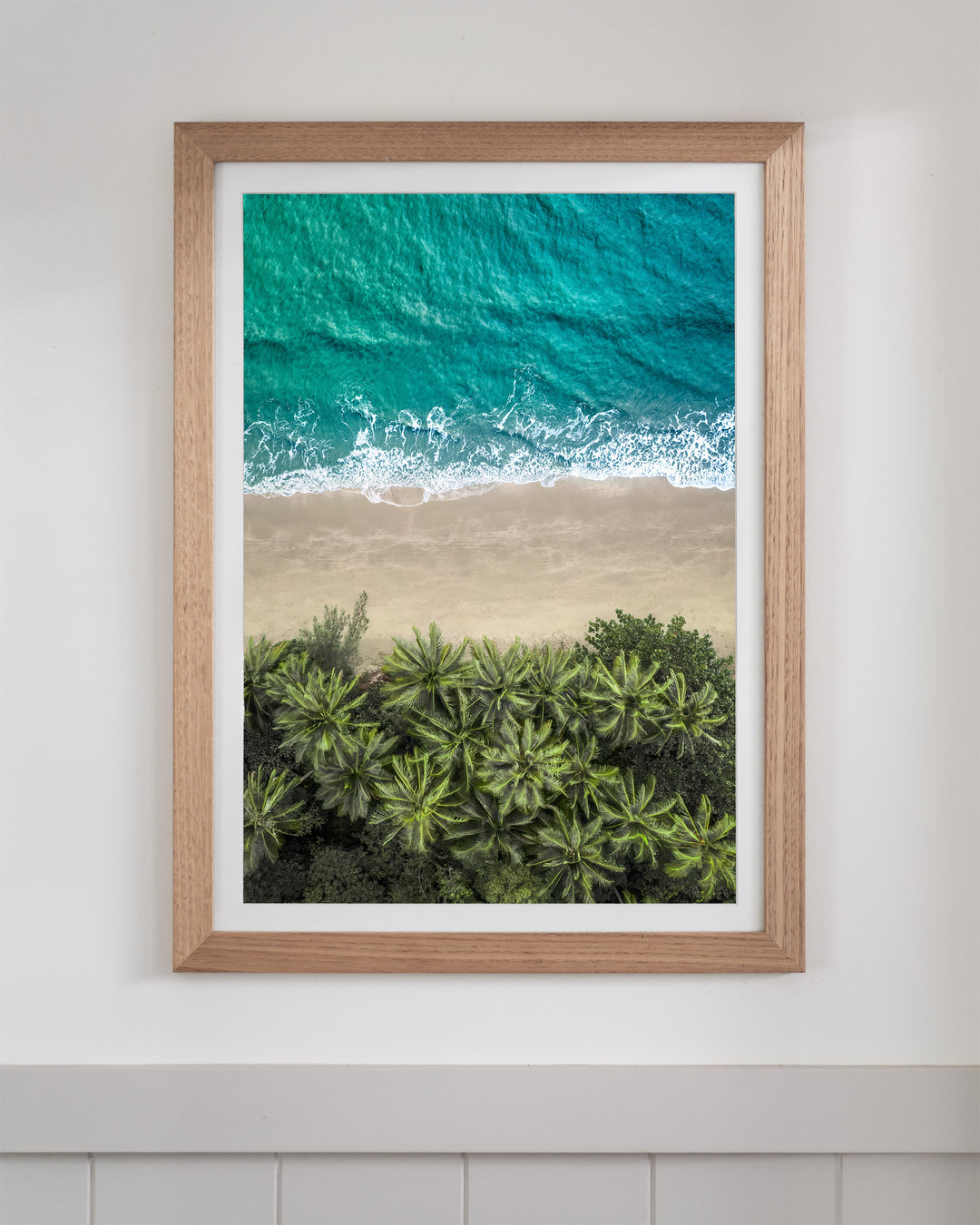 Aerial photography print titled Beachside Reverie at Four Mile Beach, featuring turquoise water, white surf, and palm trees.