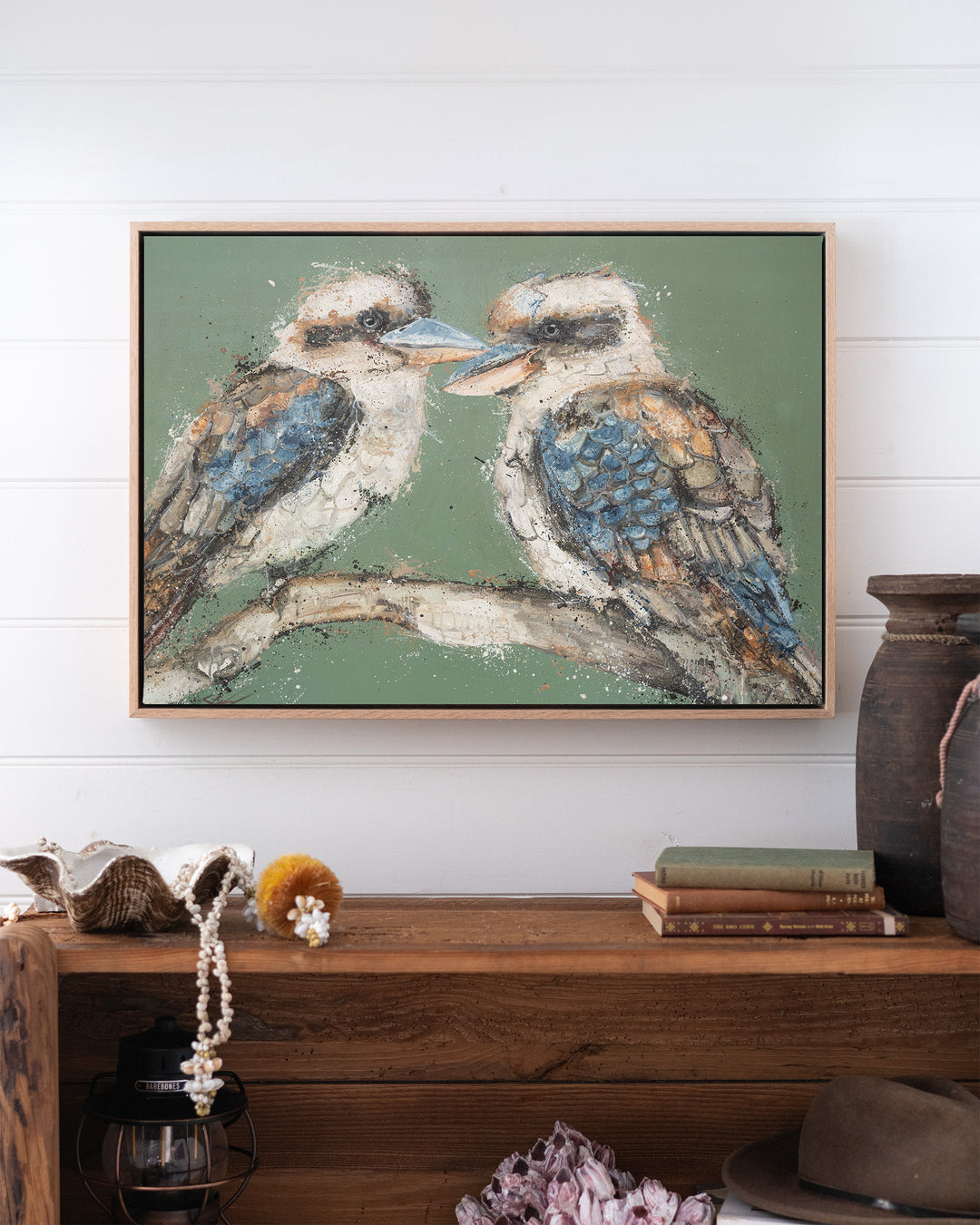 Beaks and Bedlam kookaburra fine art print by Stephanie Elizabeth, framed canvas in an oak frame above a bookshelf