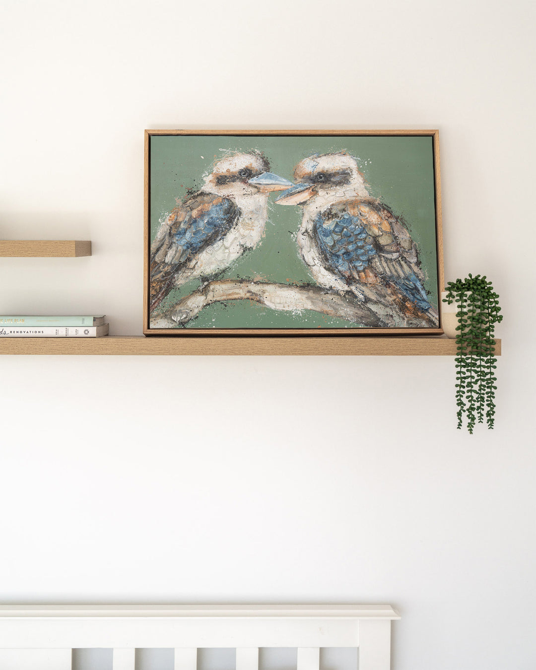 Beaks and Bedlam kookaburra fine art print by Stephanie Elizabeth, framed canvas in an oak frame on a shelf