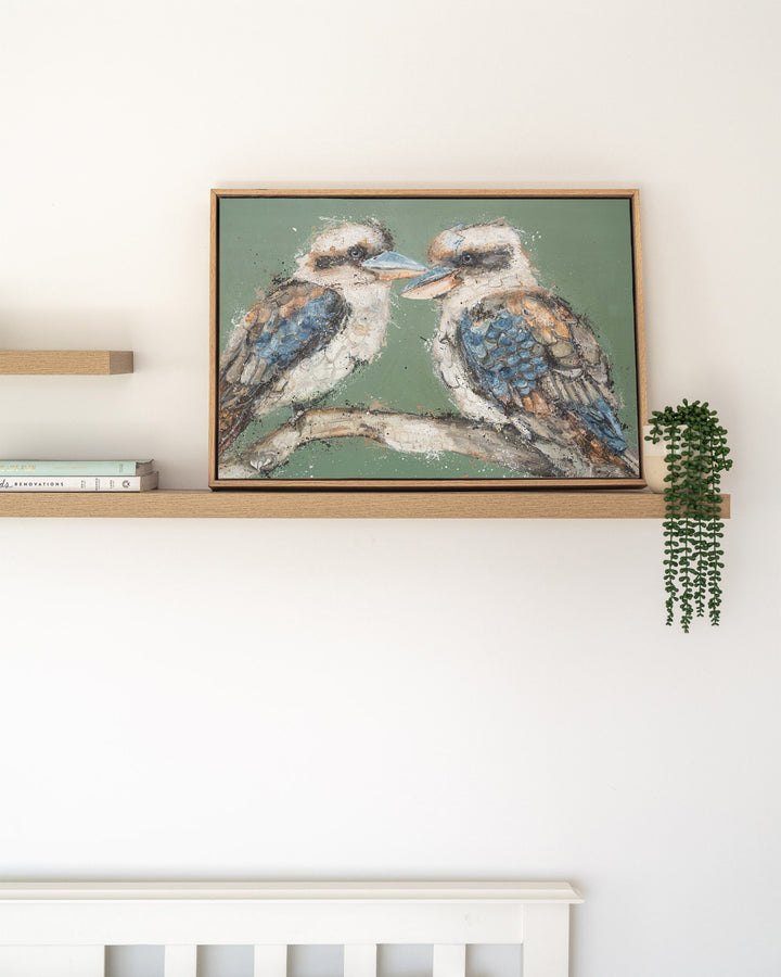 Beaks and Bedlam kookaburra fine art print by Stephanie Elizabeth, framed canvas in an oak frame on a shelf