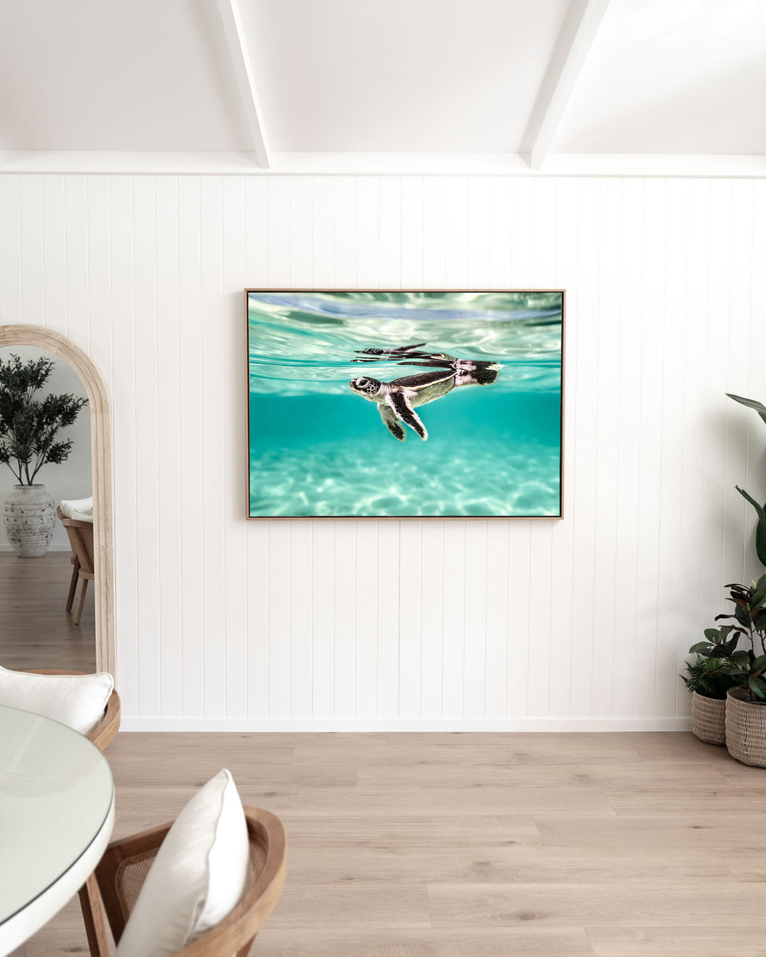 Between Two Worlds – Turtle Hatchling, Underwater Photography by David Lloyd, framed canvas print in oak float frame, styled in a dining room setting