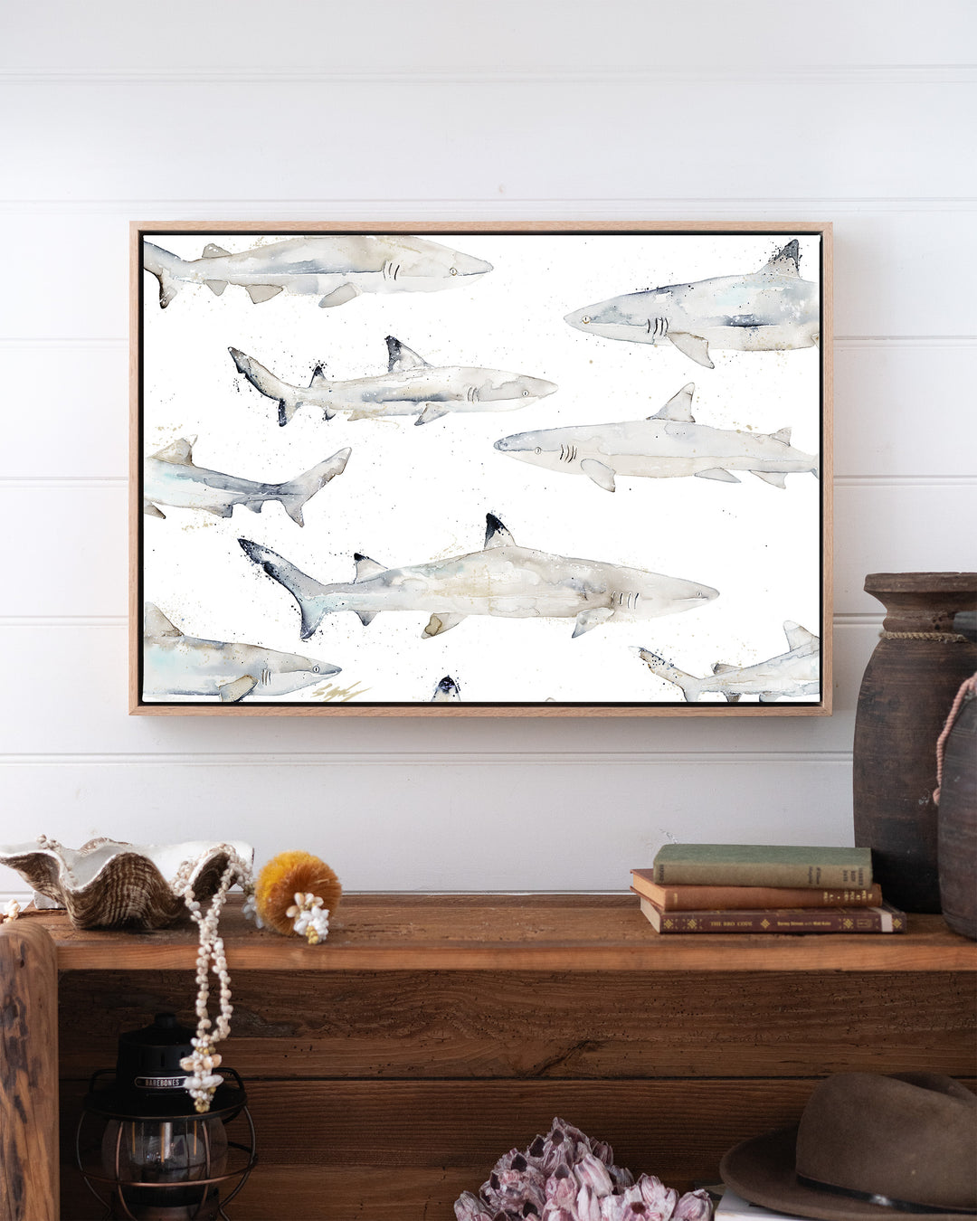 Black or White reef sharks fine art print by Stephanie Elizabeth, framed canvas in an oak frame above a bookshelf