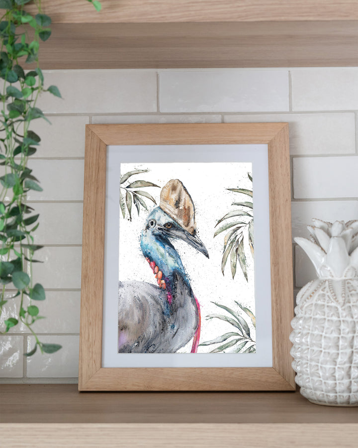 Cassowary Calamity cassowary fine art print by Stephanie Elizabeth, framed paper print in an oak frame on a kitchen shelf