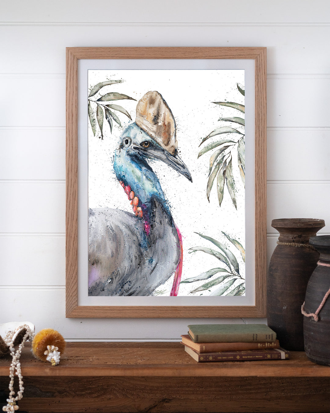 Cassowary Calamity cassowary fine art print by Stephanie Elizabeth, framed paper print in an oak frame on a shelf